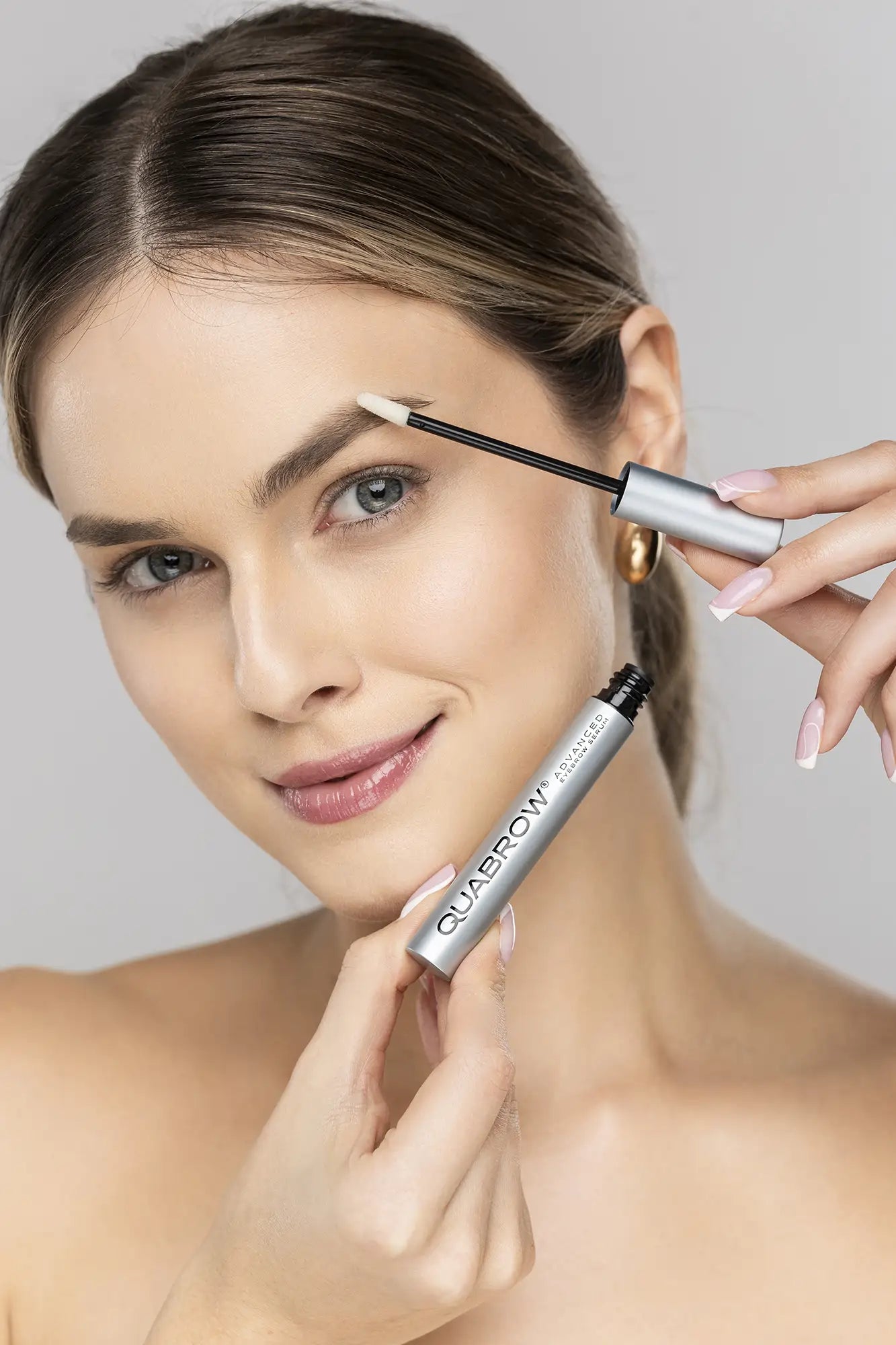 밝은 색 눈썹에 QUABROW Advanced Eyebrow Serum을 바르는 여성
