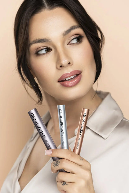 Woman holding three QUALASH &amp; QUABROW products front-facing – lash and brow care
